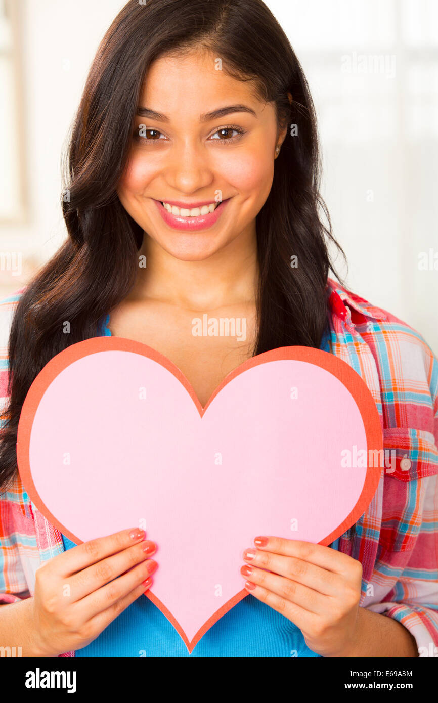 Hispanic woman holding paper heart Stock Photo