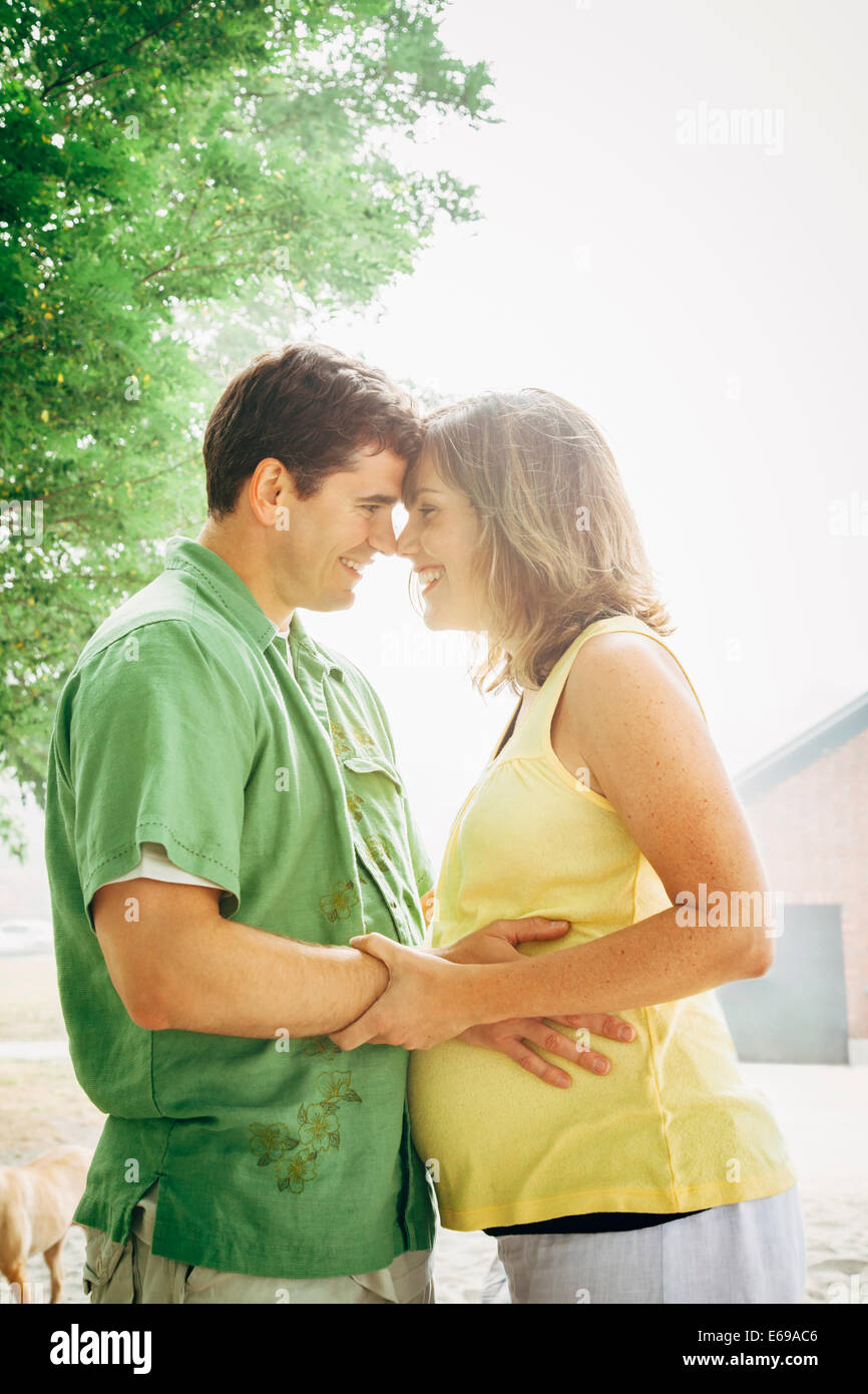 Man hugging pregnant wife outdoors Stock Photo - Alamy