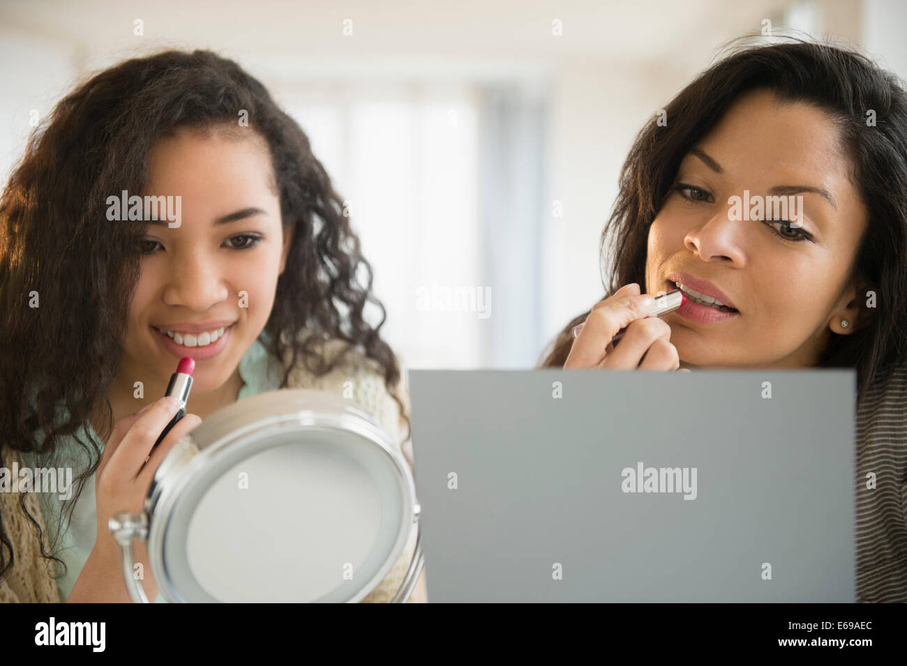 Mother and daughter applying makeup Stock Photo