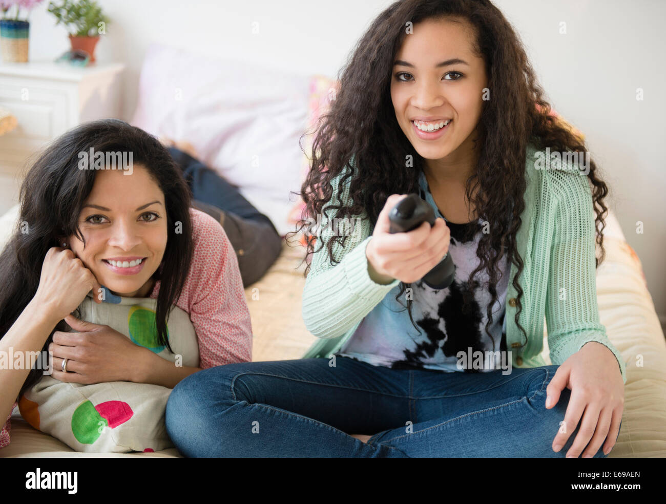 Mother and daughter watching television on bed Stock Photo