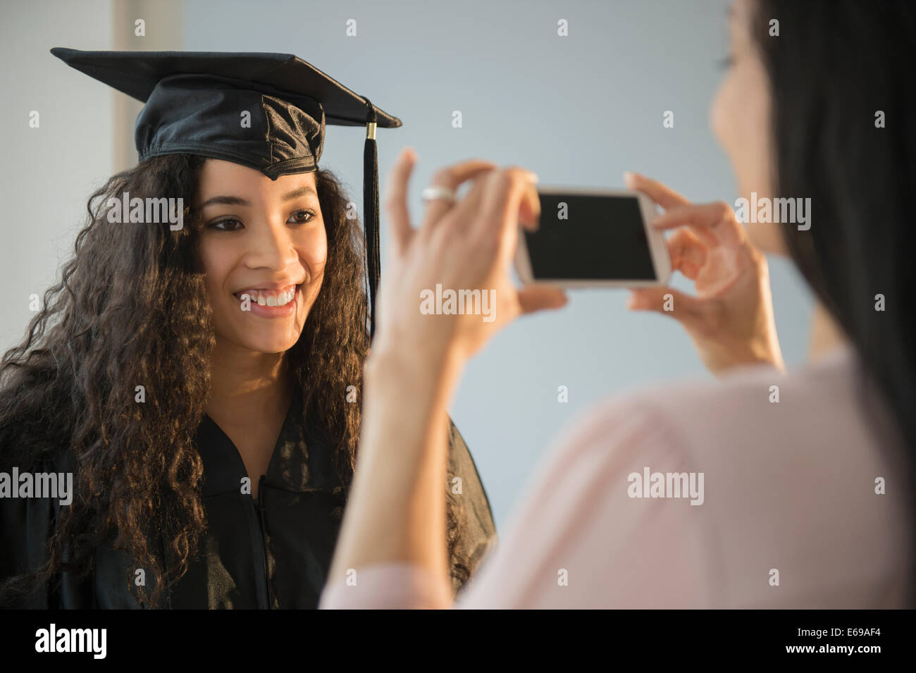 Mother photographing daughter at graduation Stock Photo