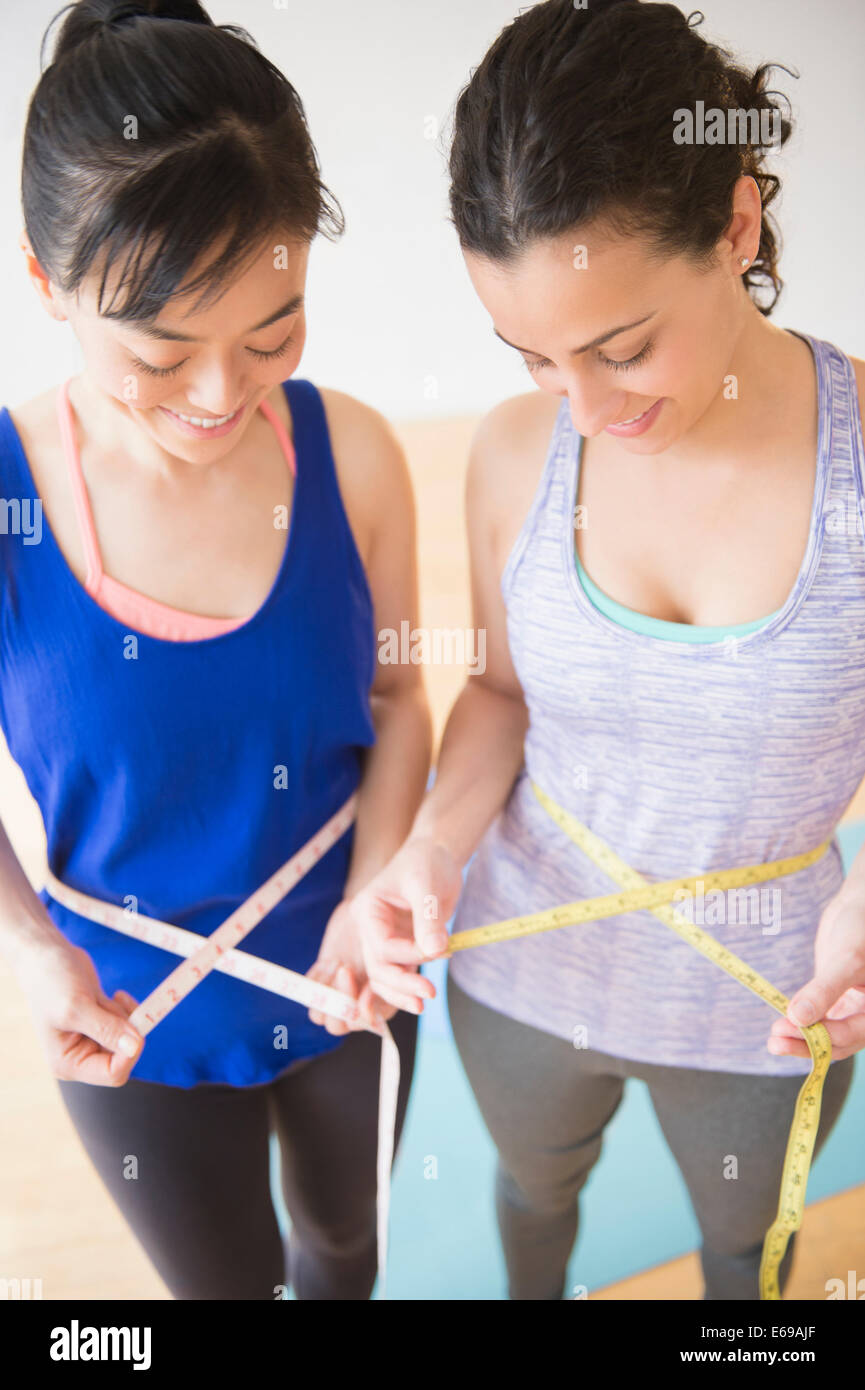 Women measuring their waists Stock Photo