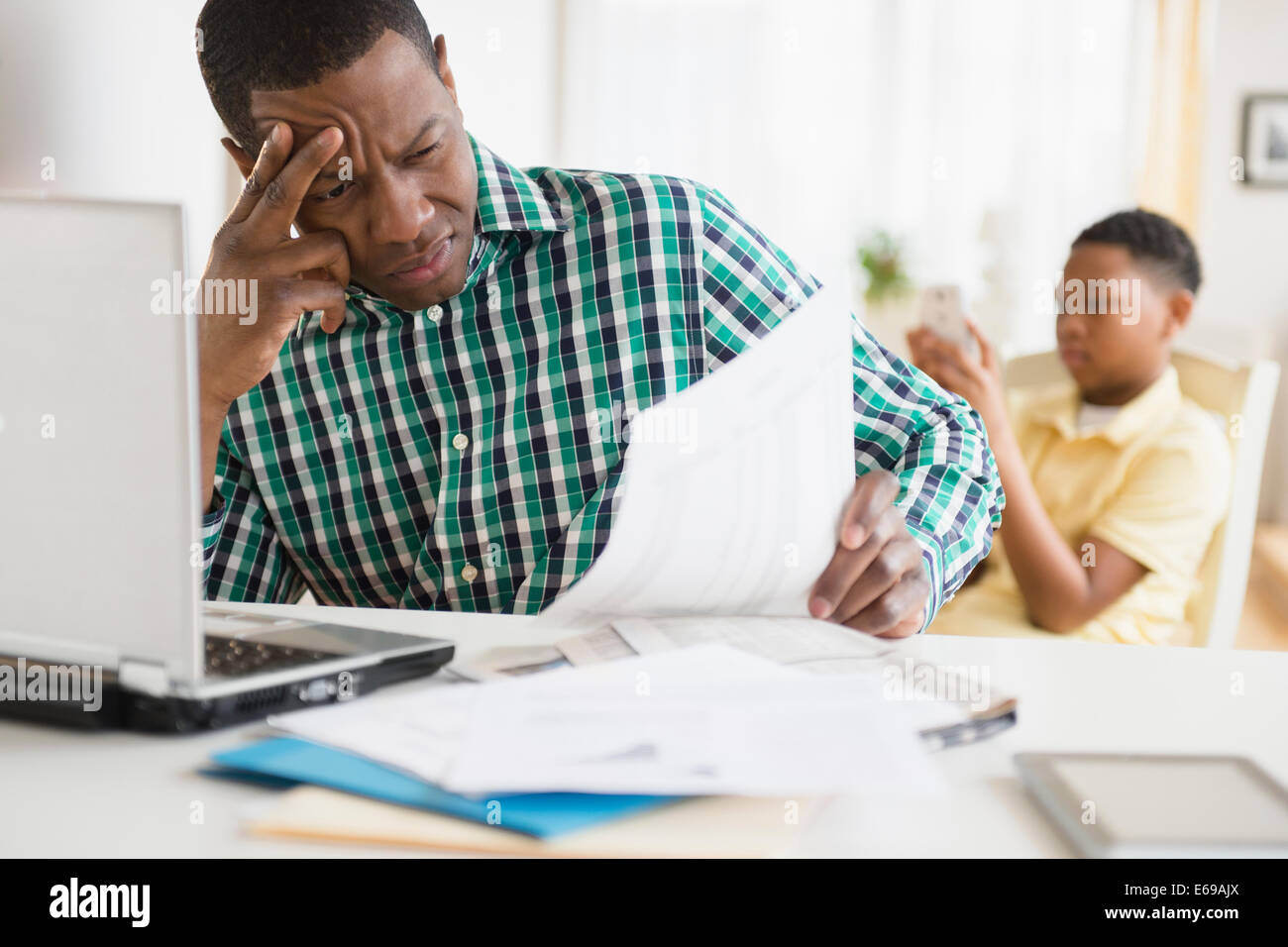 Anxious father paying bills online Stock Photo