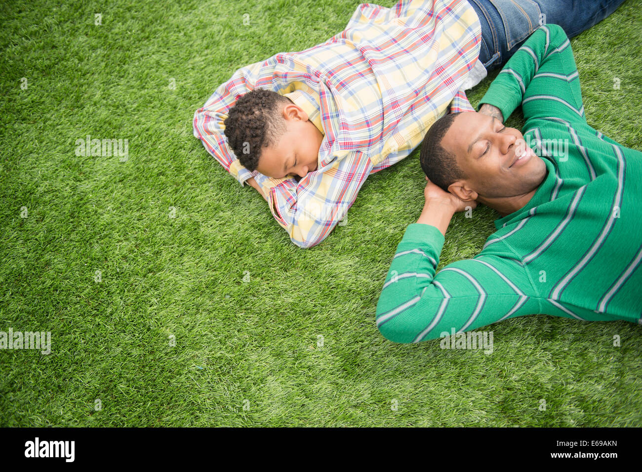 Father and son relaxing in grass Stock Photo