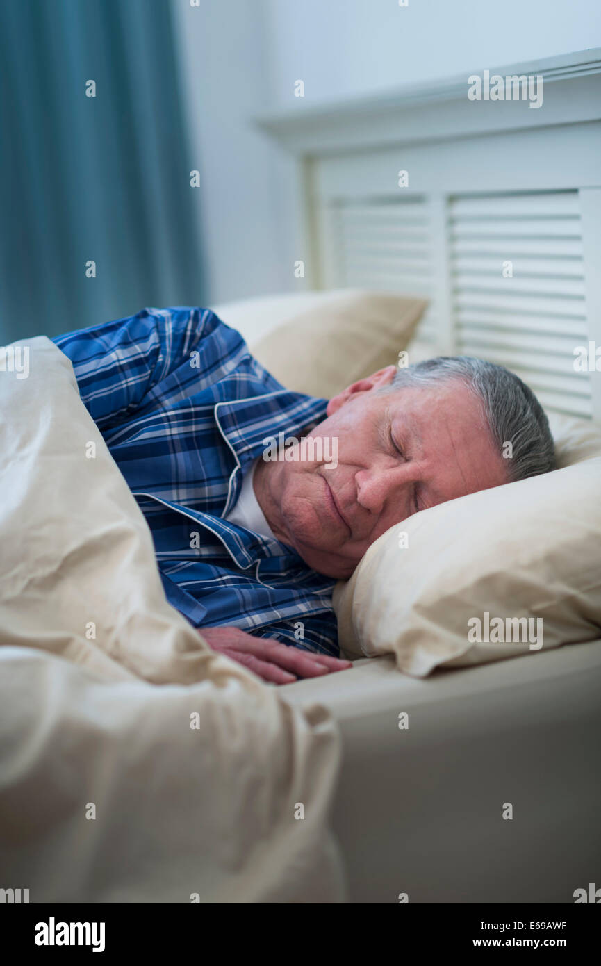 Senior Caucasian man sleeping in bed Stock Photo - Alamy