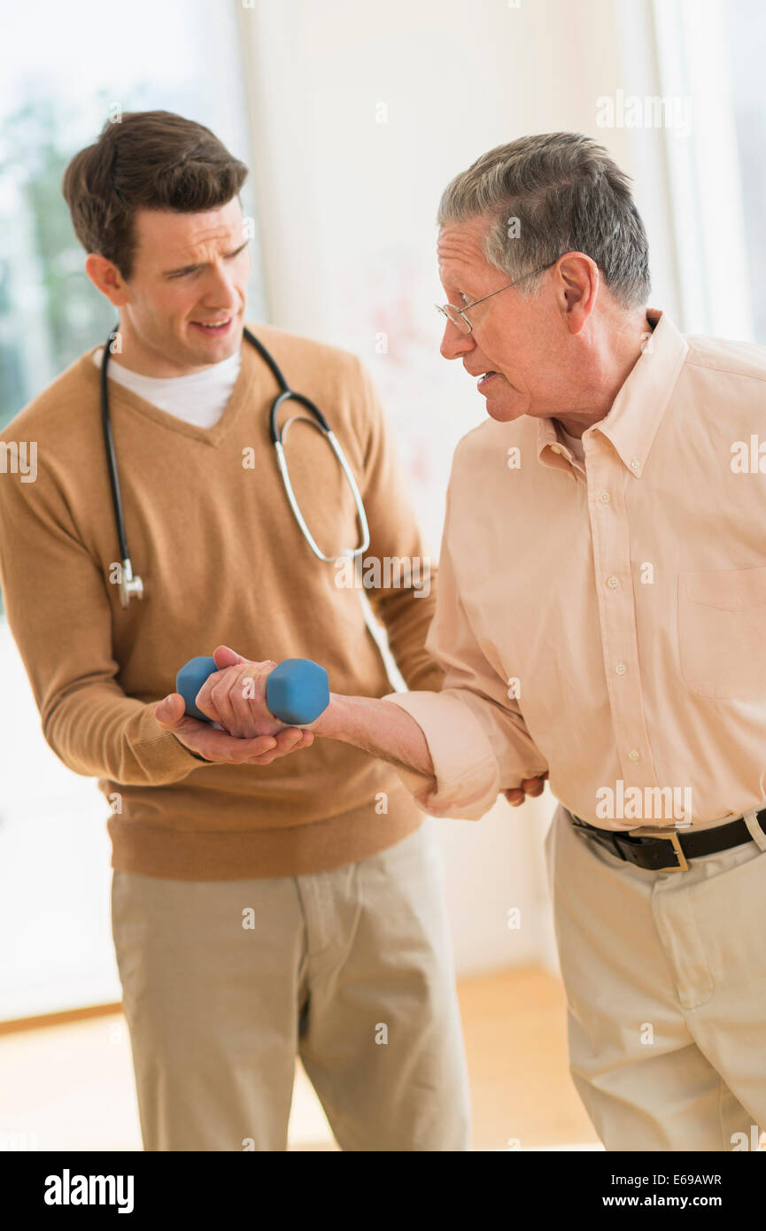 Senior Caucasian man working with physical therapist Stock Photo