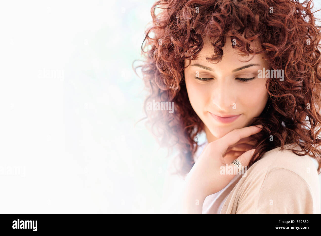 Hispanic woman holding chin in hands Stock Photo