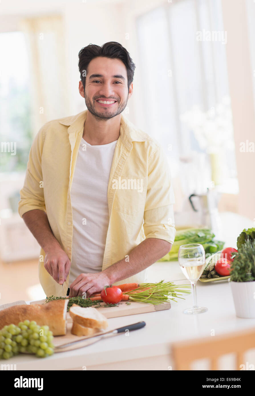 Mixed race man cooking in kitchen Stock Photo