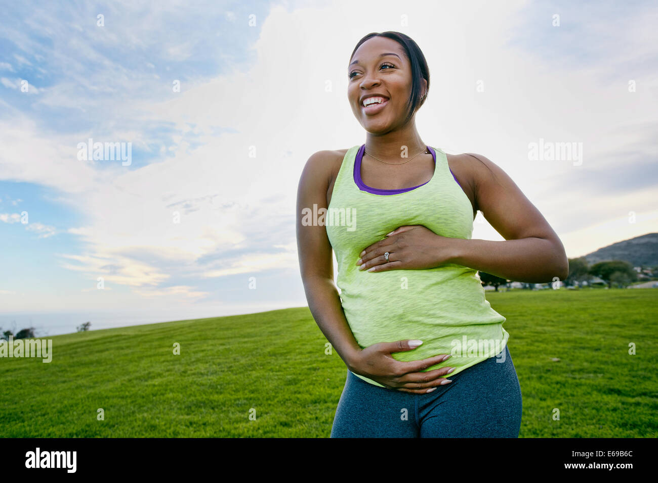 Pregnant woman laughing in park Stock Photo