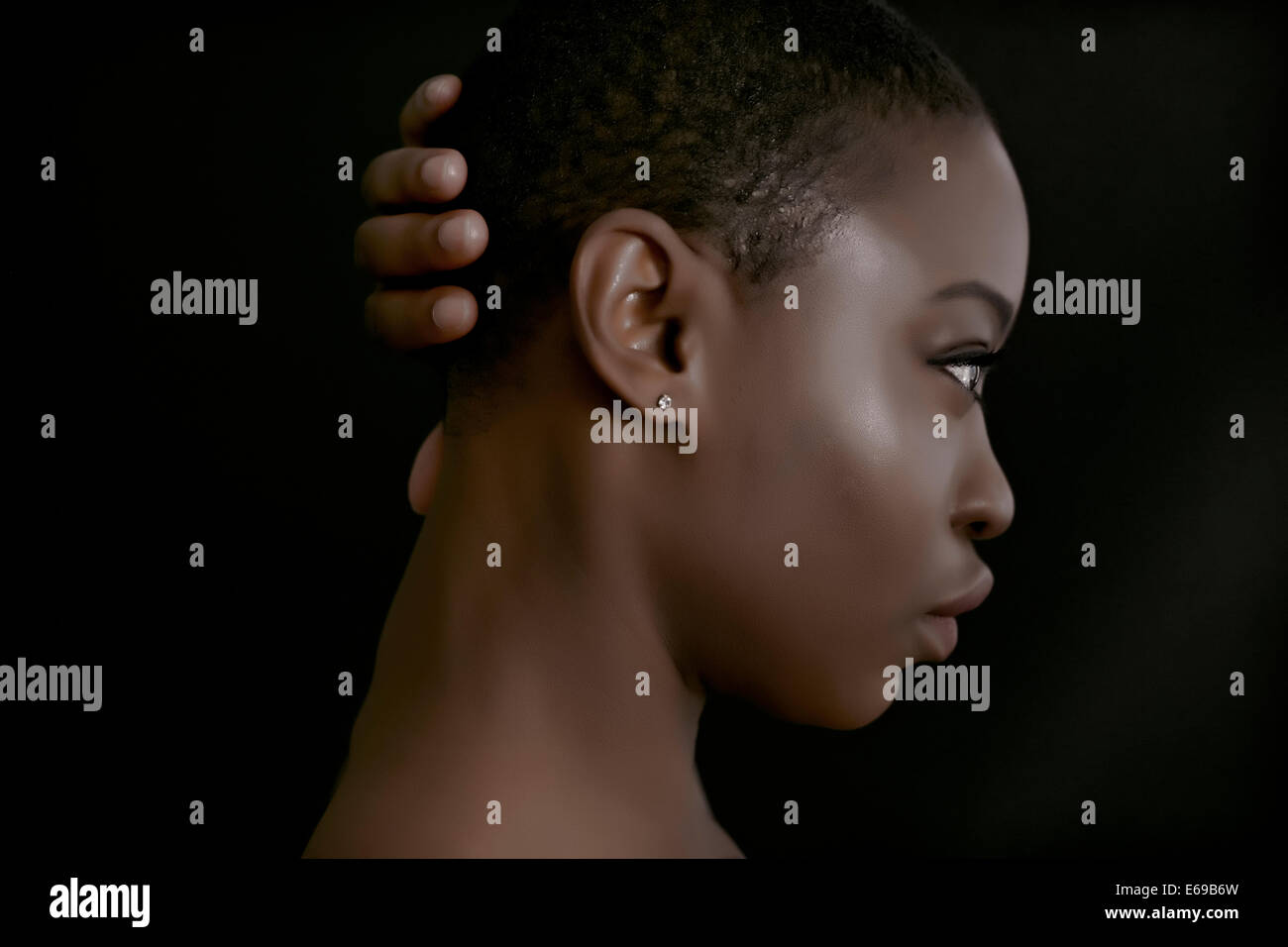 Black woman with hand behind head Stock Photo