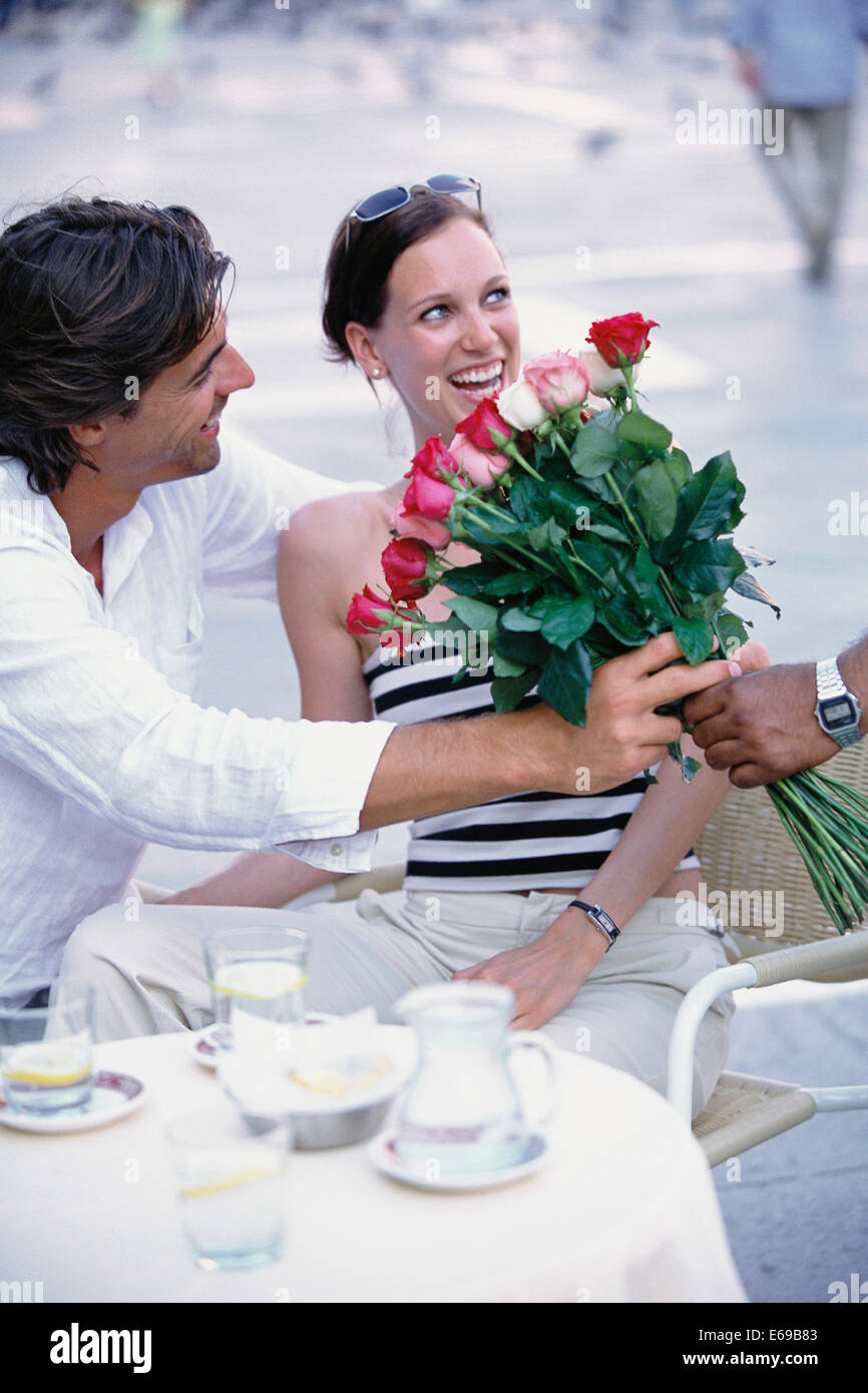 Man buying flowers for girlfriend at sidewalk cafe Stock Photo Alamy