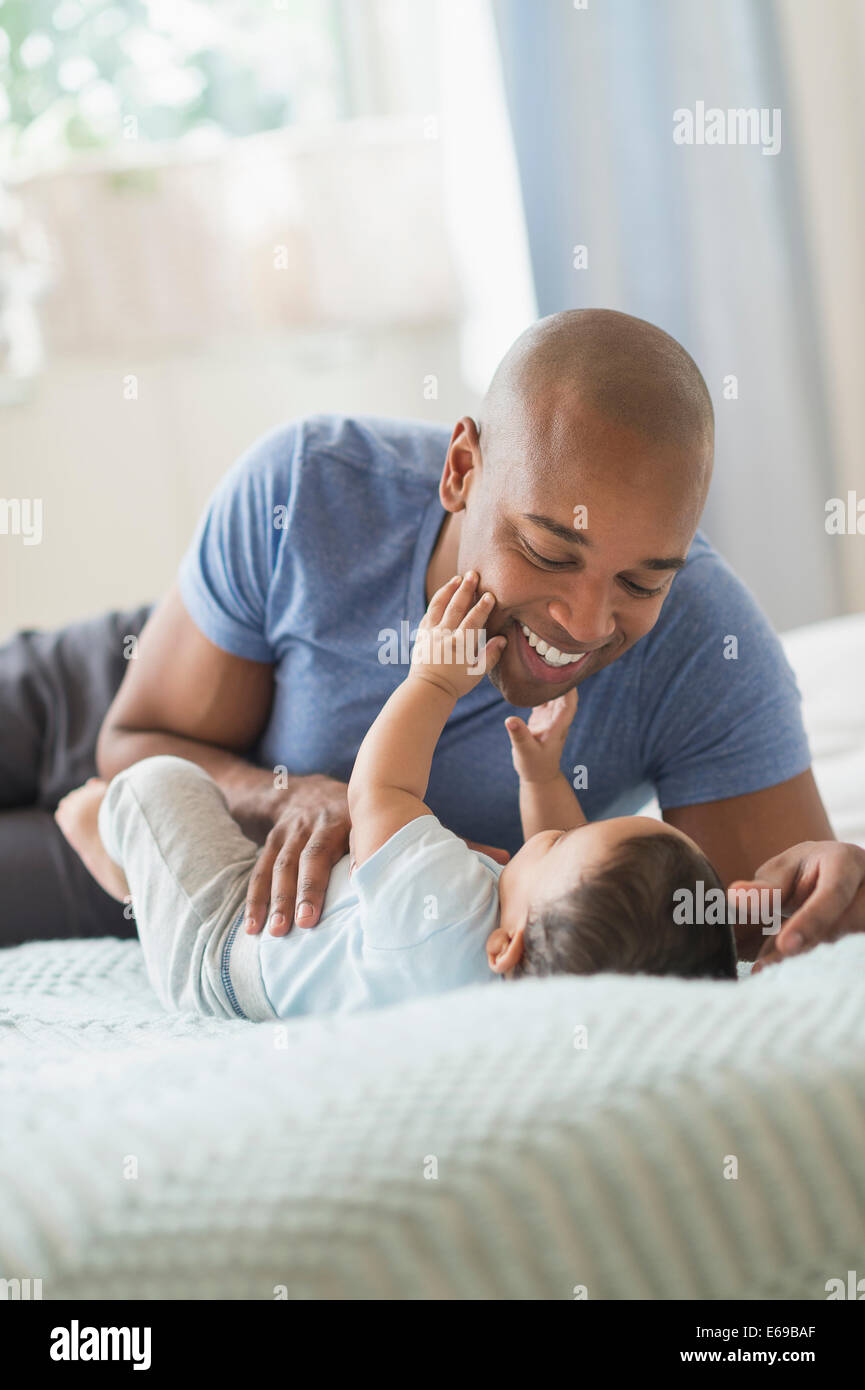 Father playing with baby on sofa Stock Photo