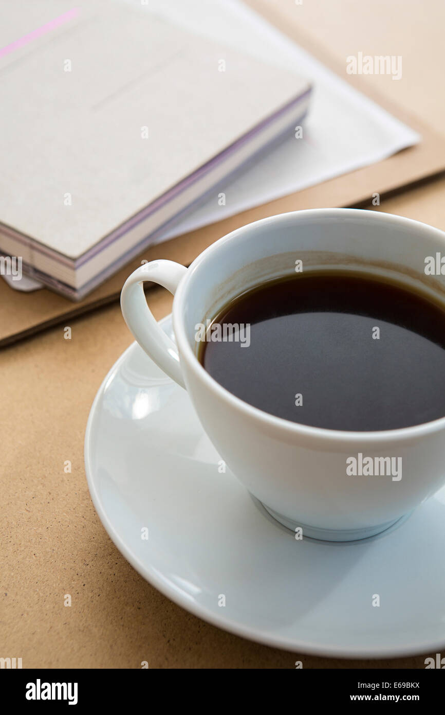 Cup of coffee on table with book Stock Photo