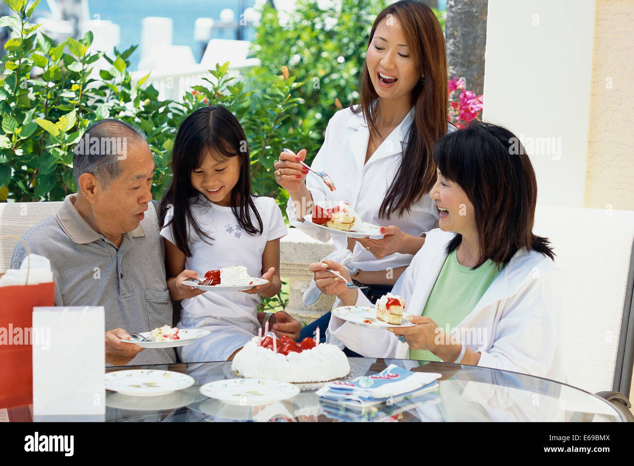 Family eating cake together at birthday Stock Photo