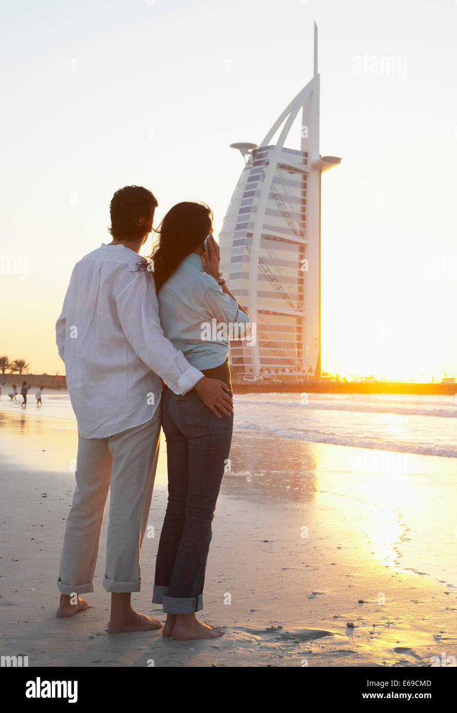 Couple admiring monument on beach, Dubai, United Arab Emirates Stock Photo