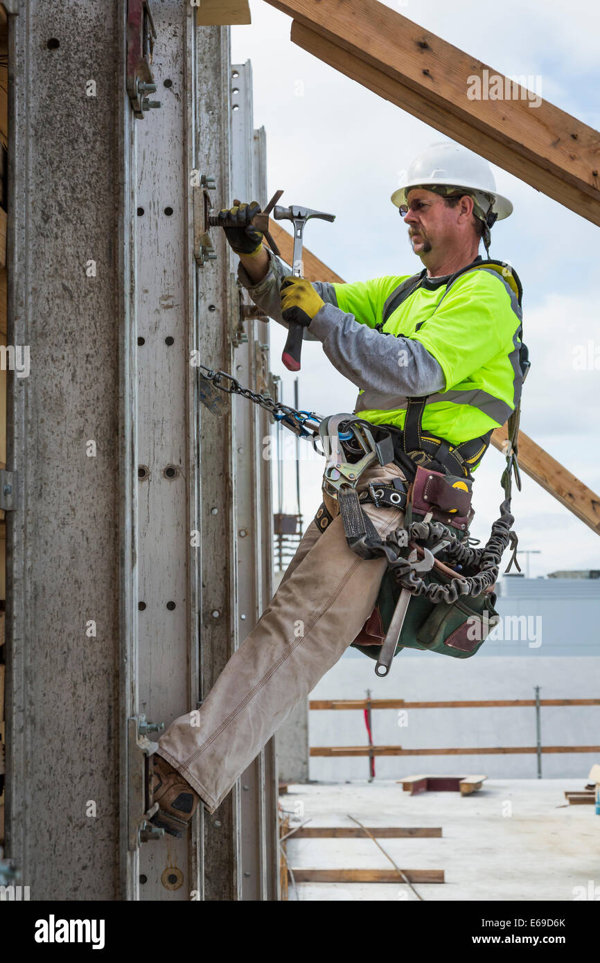 Caucasian worker hammering nails at construction site Stock Photo