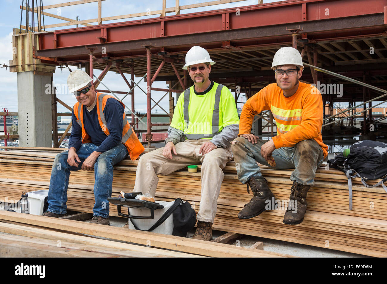 Caucasian workers smiling at construction site Stock Photo