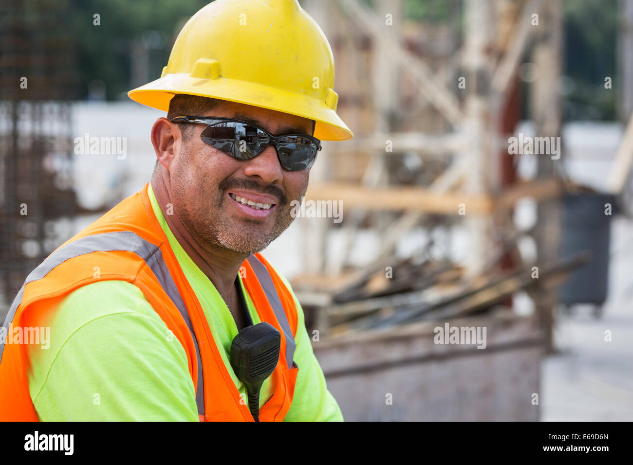 Hispanic worker smiling at construction site Stock Photo