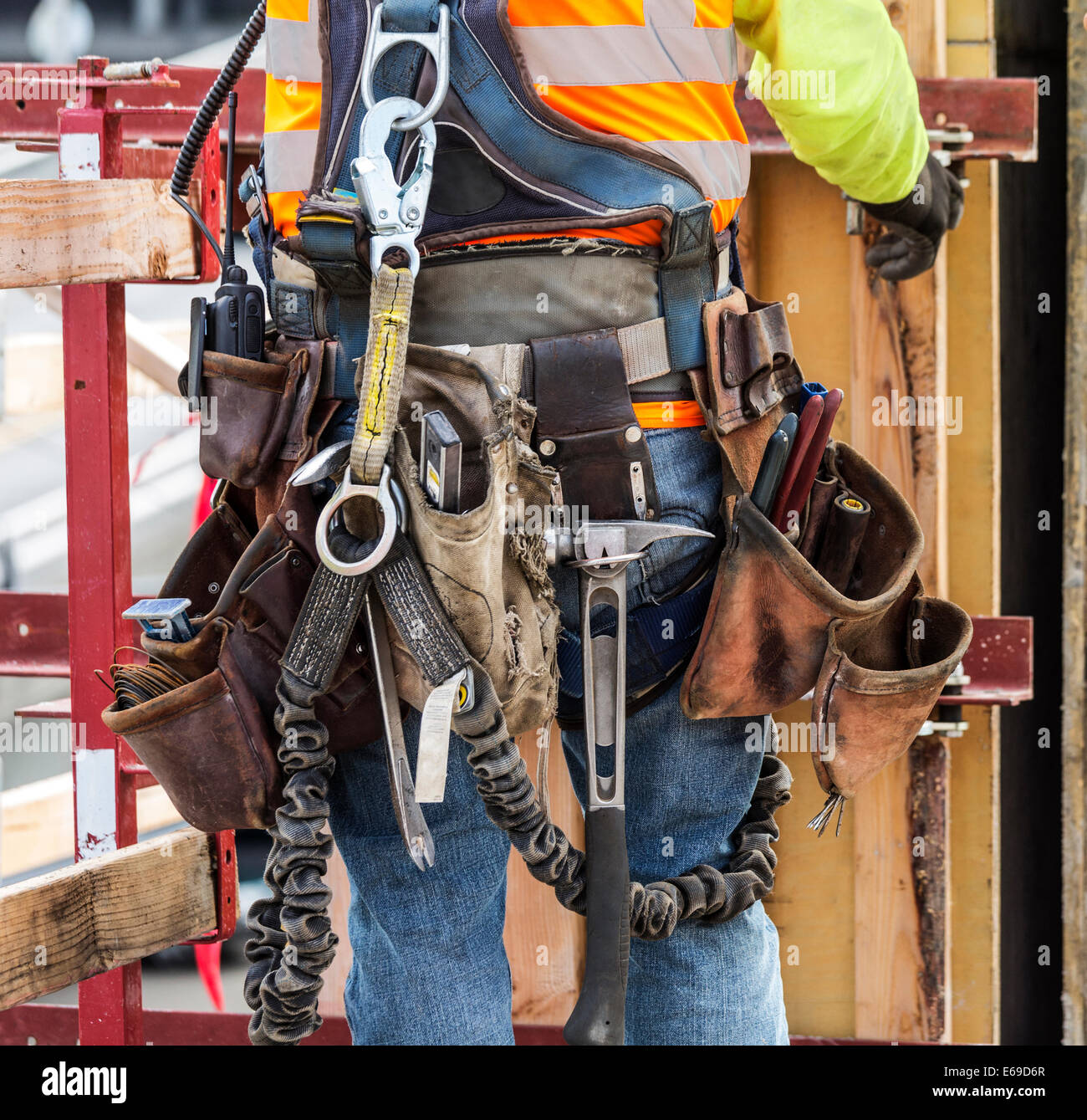Hispanic worker wearing tool belt at construction site Stock Photo