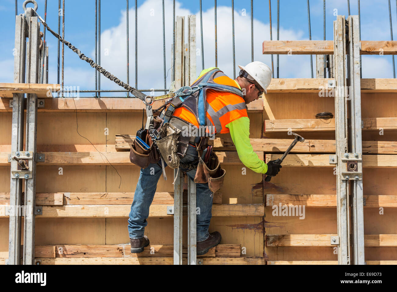 Caucasian worker hammering wood at construction site Stock Photo