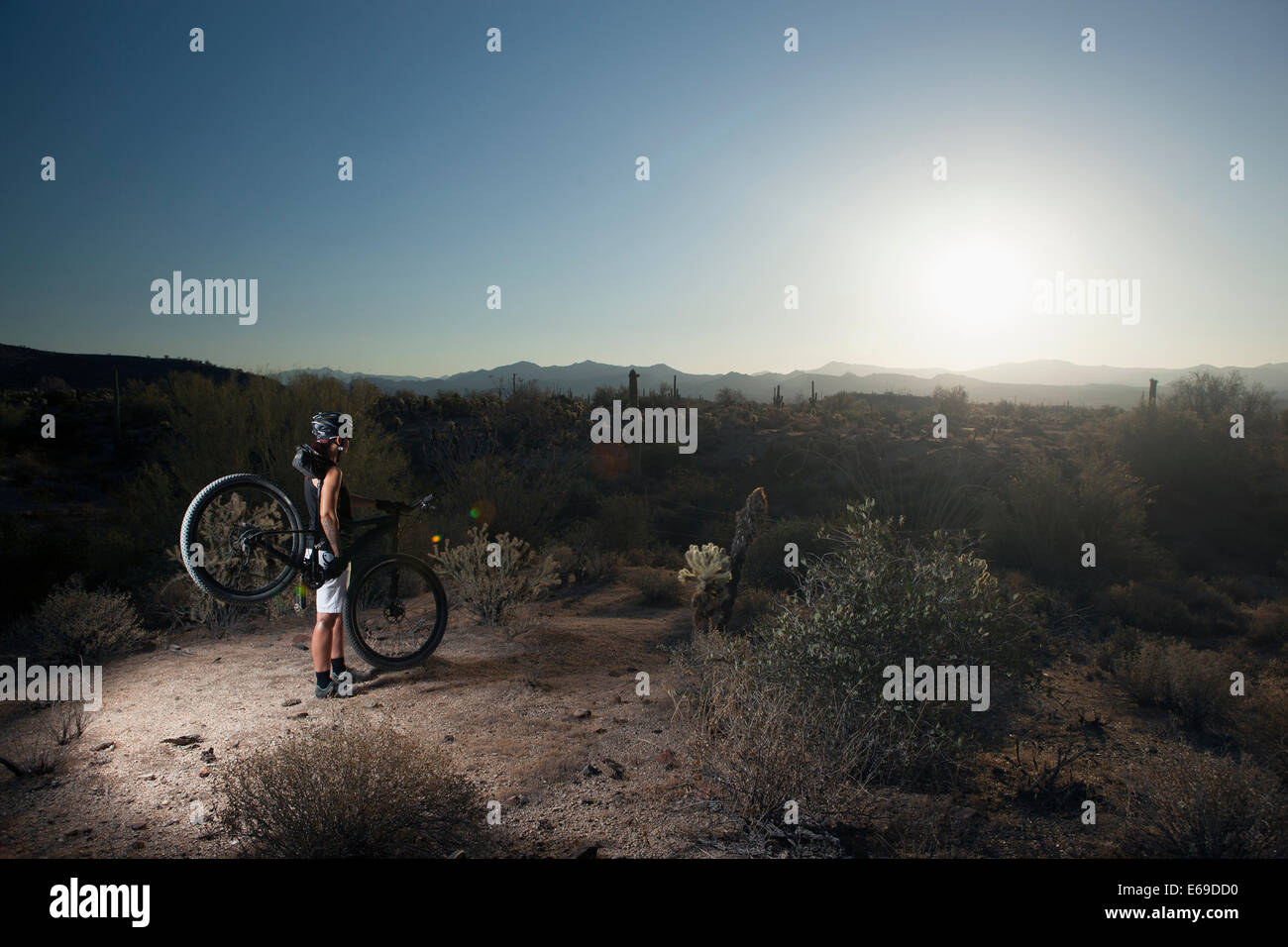 Mountain biker standing in desert Stock Photo