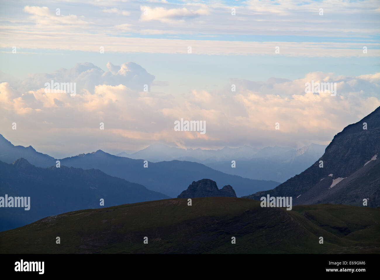 Overlapping mountain ridges in several shades of blue at sunrise Stock Photo