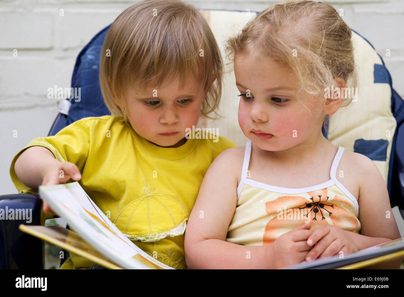 2 children,book,reading,looking Stock Photo