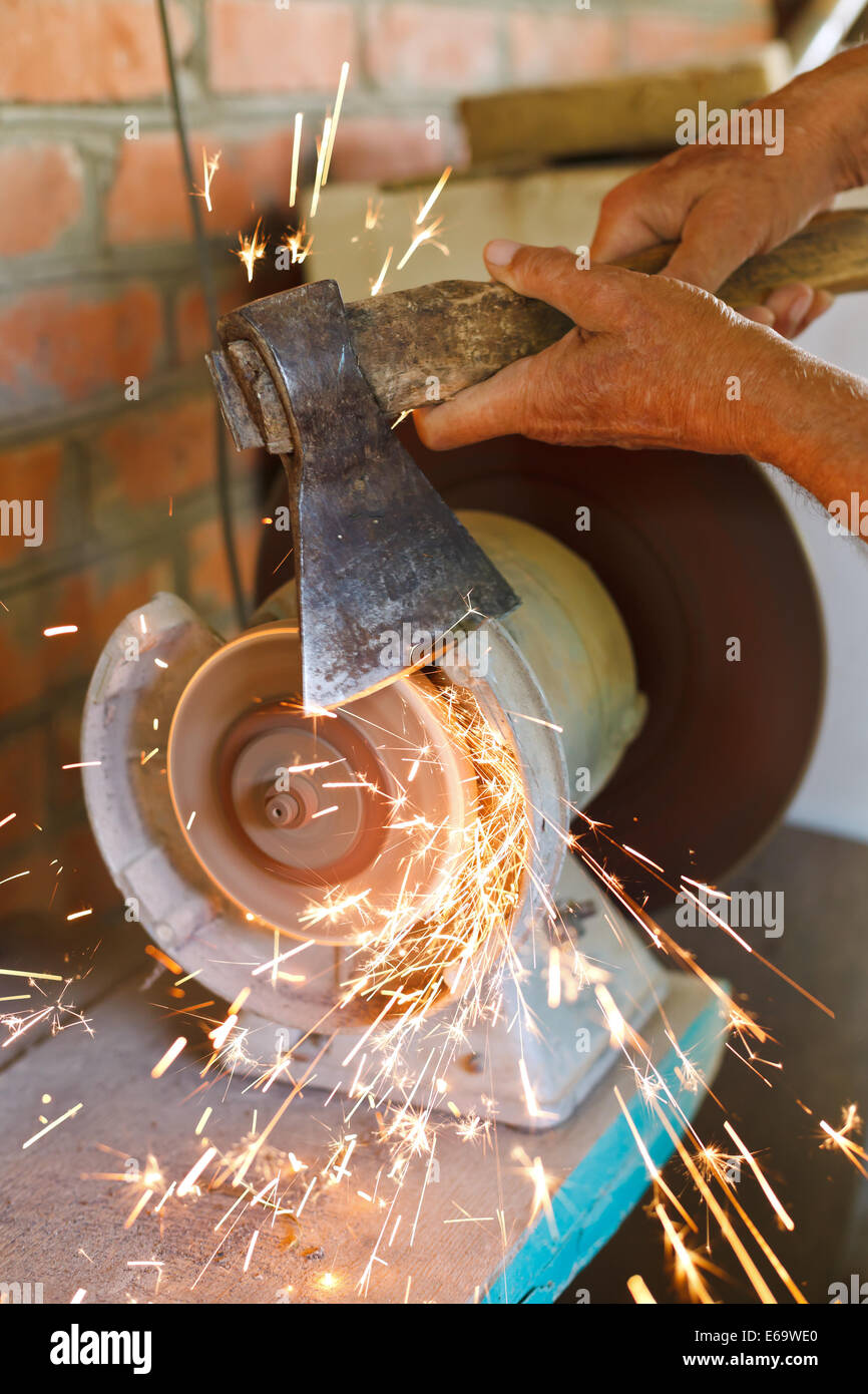 grinding bench axe using a grinding machine close up Stock Photo