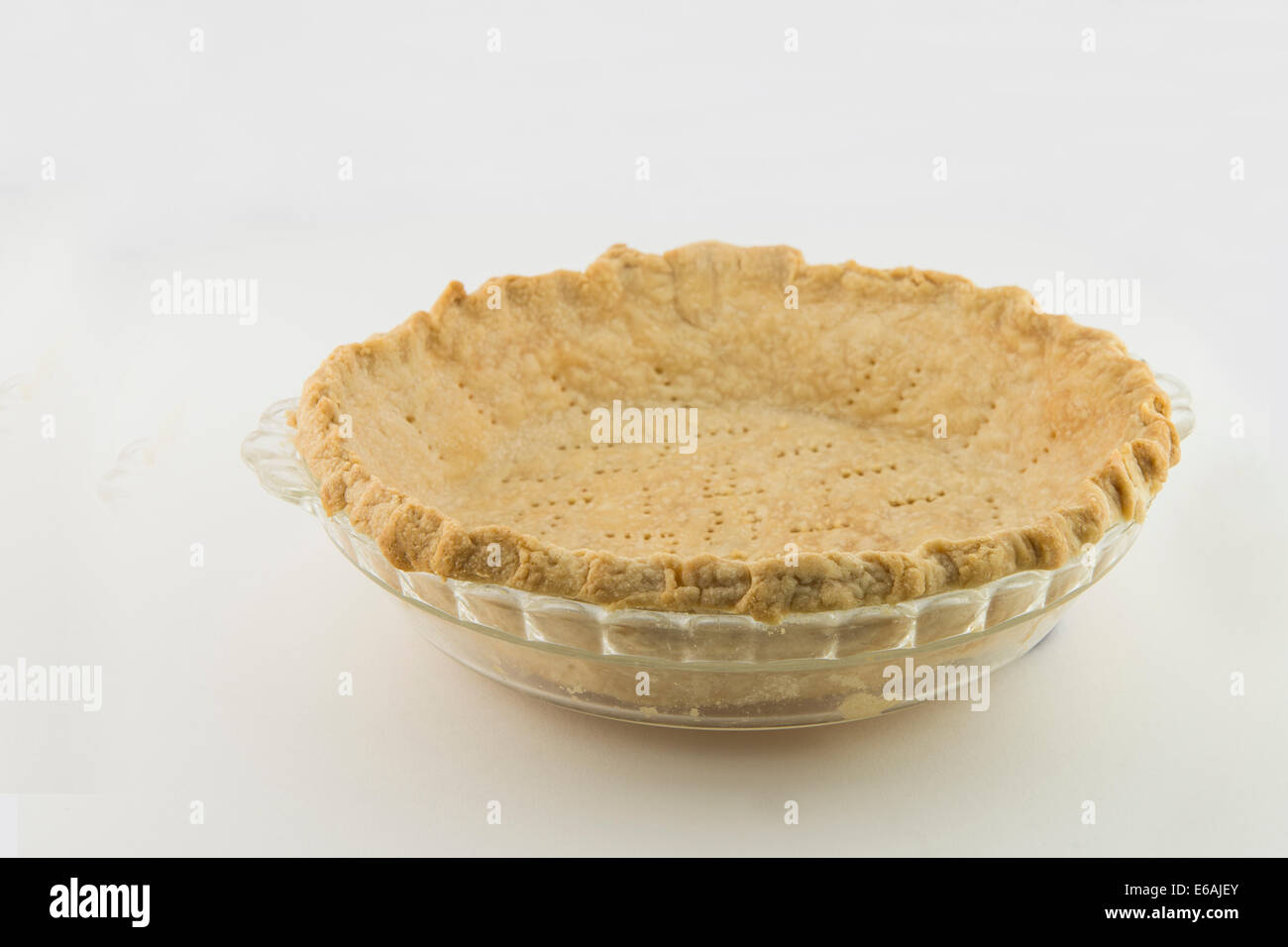 A browned, freshly baked homemade pie shell crust waiting for filling. Isolated on white. USA Stock Photo