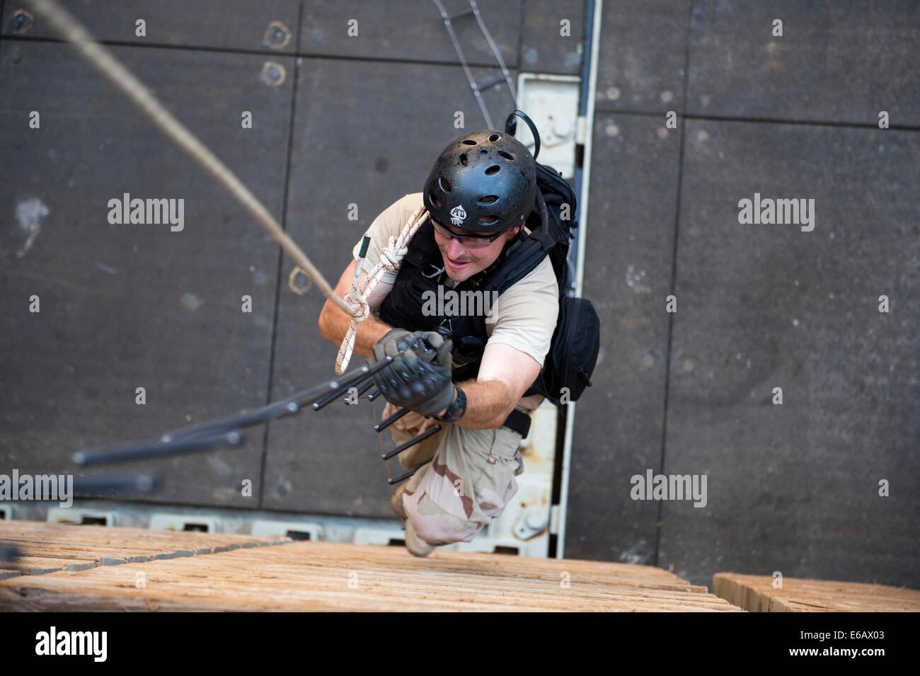 U.S. Navy Boatswain's Mate 3rd Class Chase Burton climbs a caving