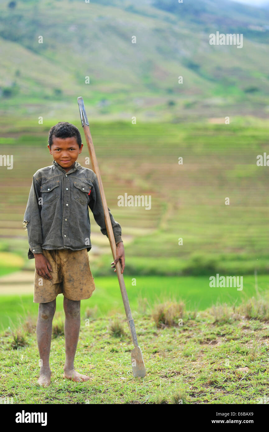 Madagascar, Ambalavao, young boy posing in front of terraced rice fields. Stock Photo