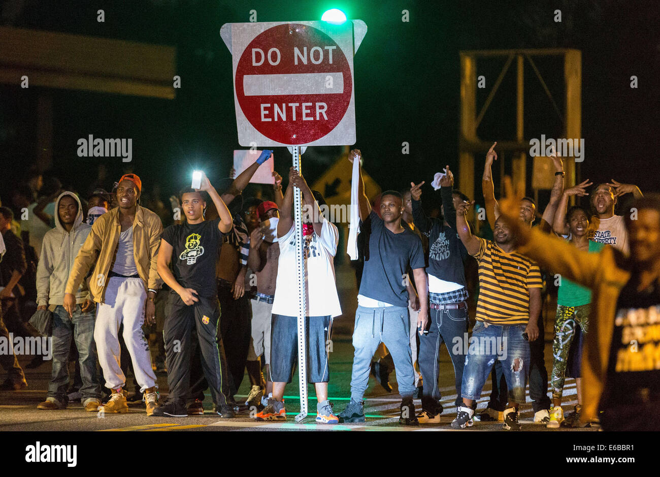 Ferguson, USA. 18th Aug, 2014. Protestors carrying broken street signs block the road during protests against police killing of Michael Brown in Ferguson, Missouri, the United States, around midnight of Aug. 18, 2014. On Aug. 9, 18-year-old African American Michael Brown was shot dead by police in Ferguson, sparking continuous protests in the town where most of the population is black. Credit:  Shen Ting/Xinhua/Alamy Live News Stock Photo