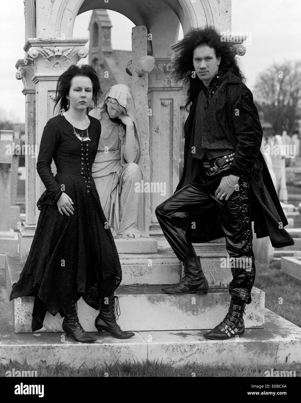 young fashionable goths dressed in black in a church graveyard