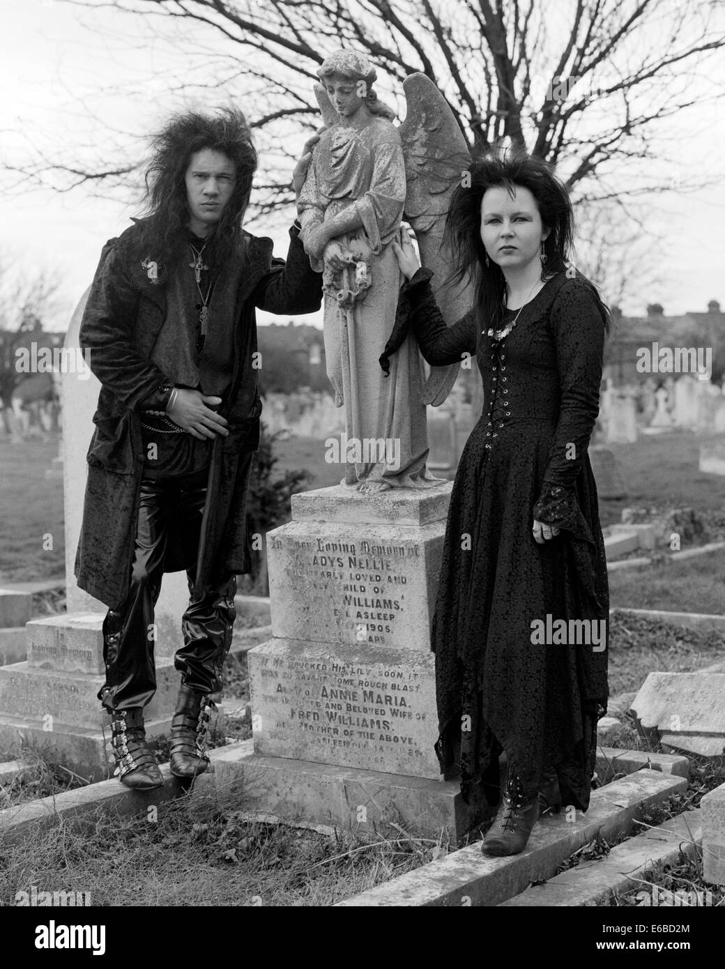 young fashionable goths dressed in black in a church graveyard