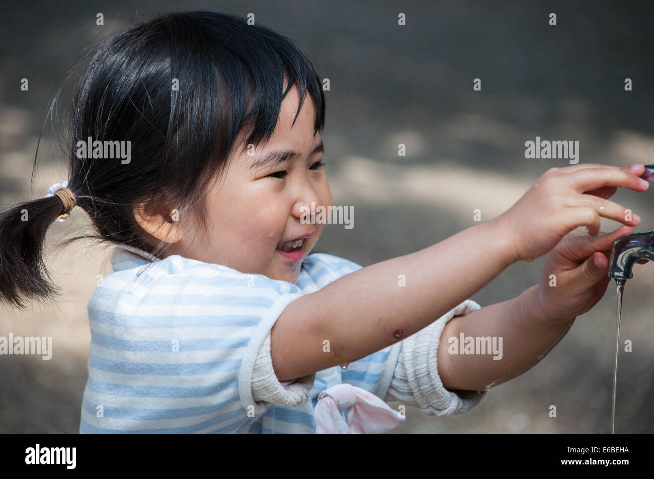 Japanese little girl taking water fountain Stock Photo