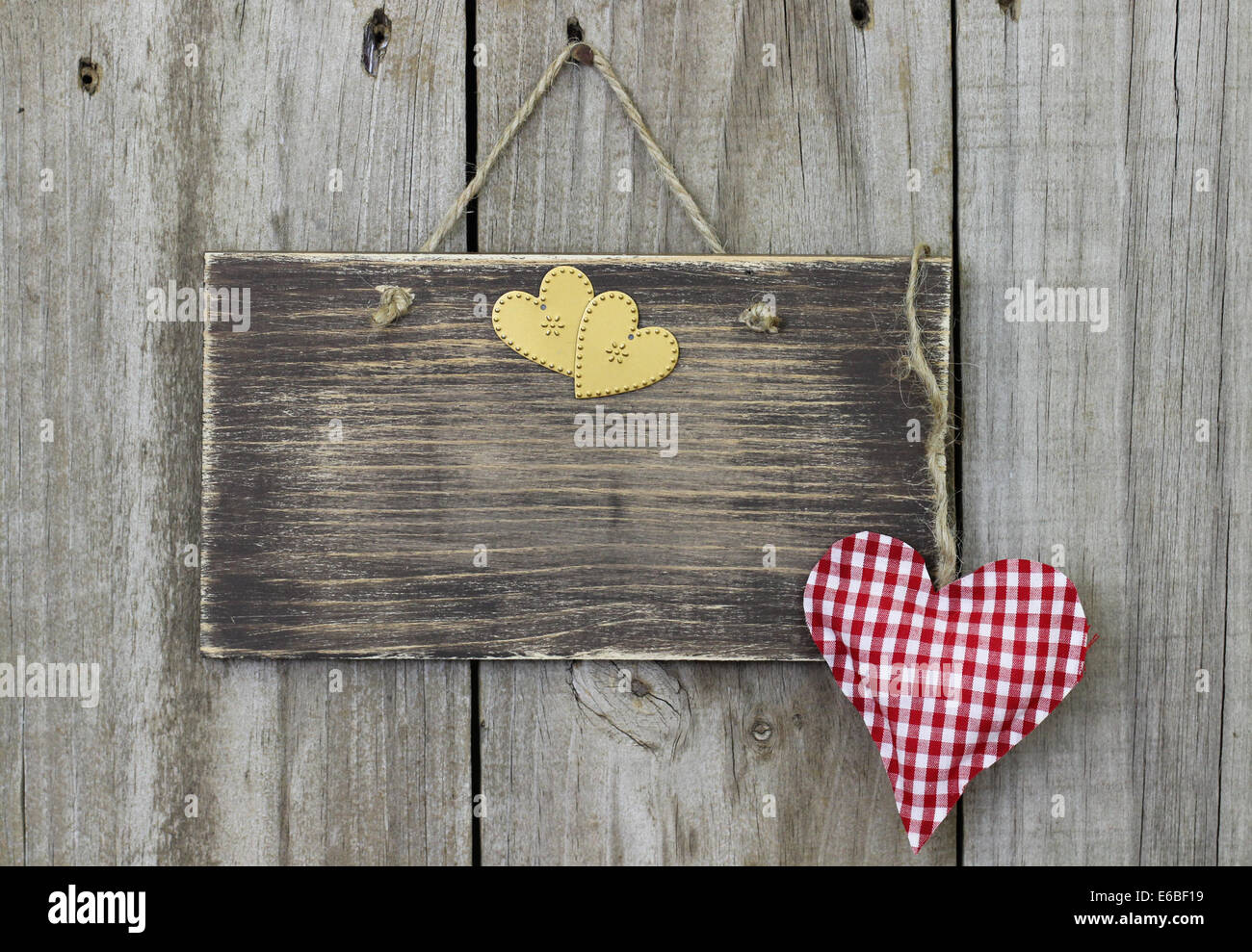 Blank rustic sign with red checkered and gold hearts hanging on old ...