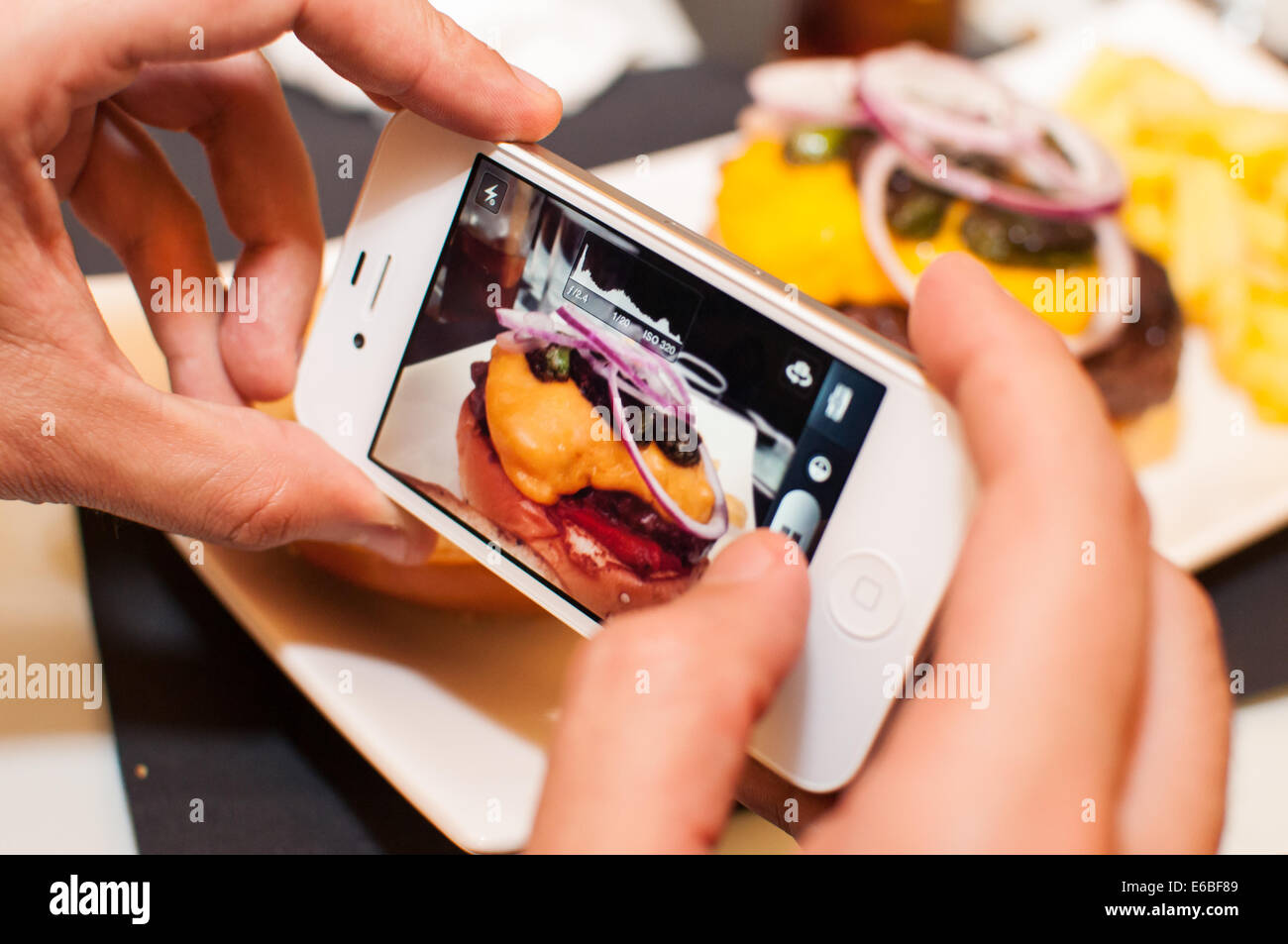 Photograph of a hamburger through a smartphone Stock Photo