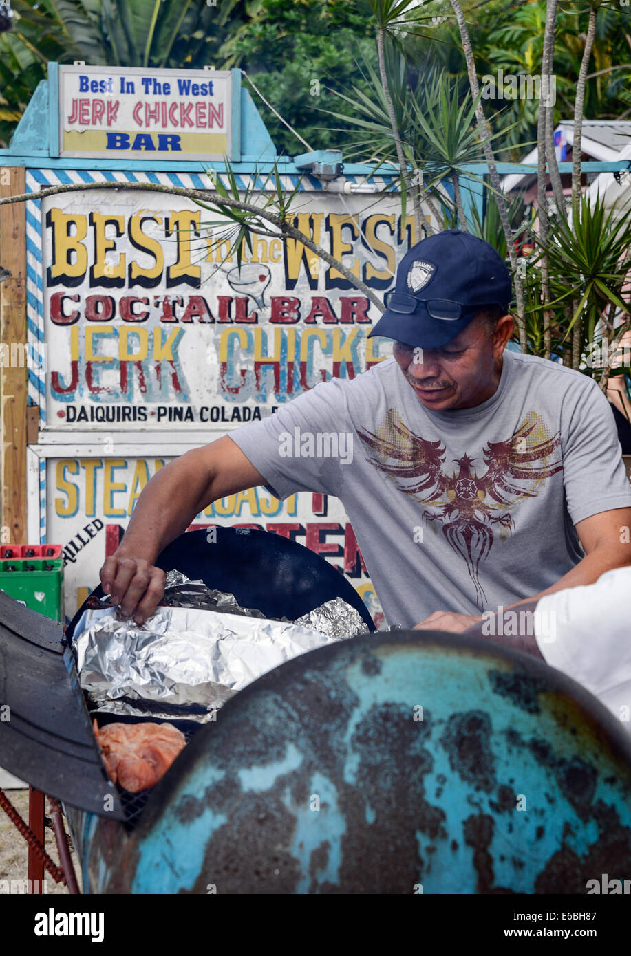 Jamaican man prepares jerk chicken in an oil barrel grill, Negril, Jamaica Stock Photo