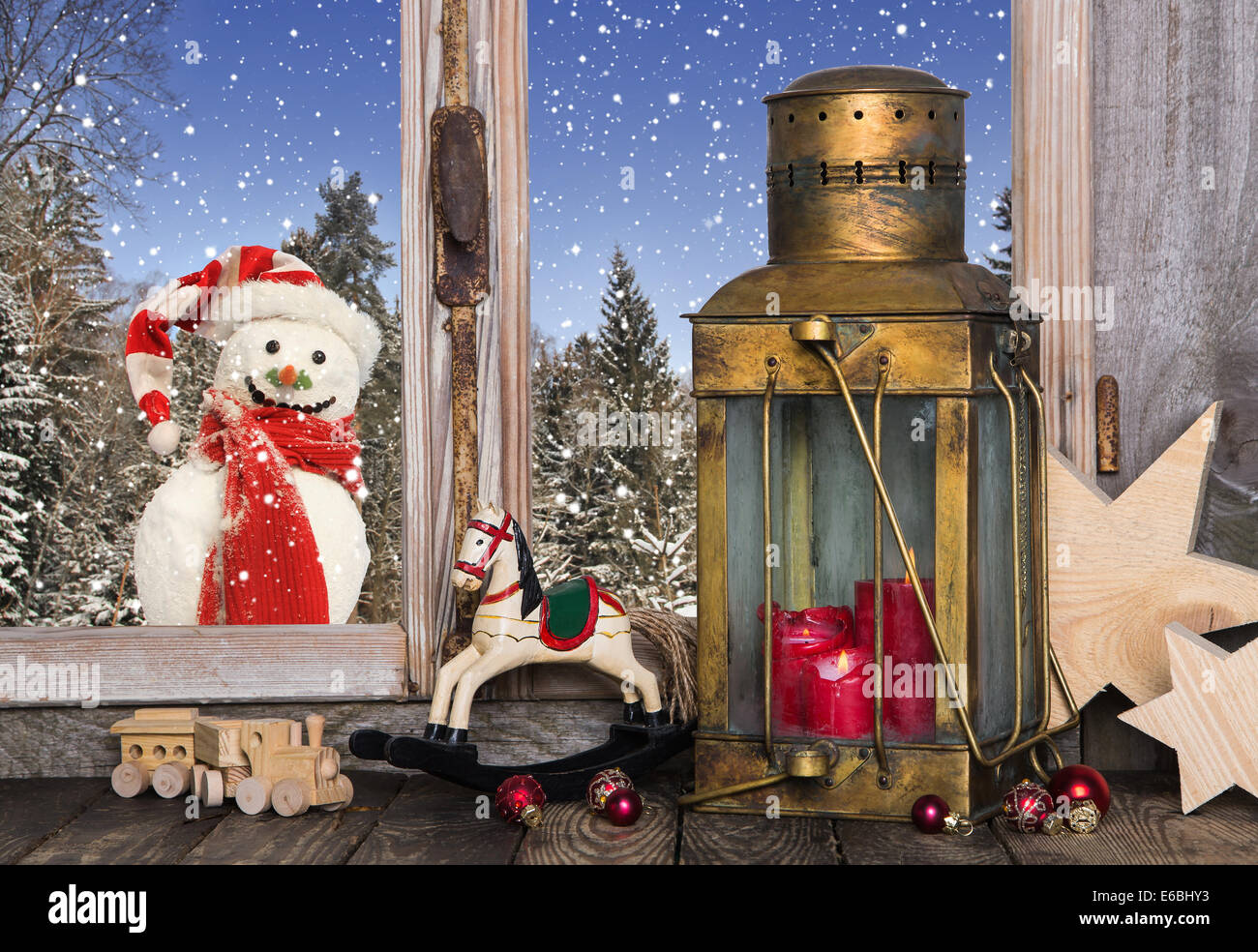 Christmas window decoration with old toys and an old lantern with a red candle. Stock Photo