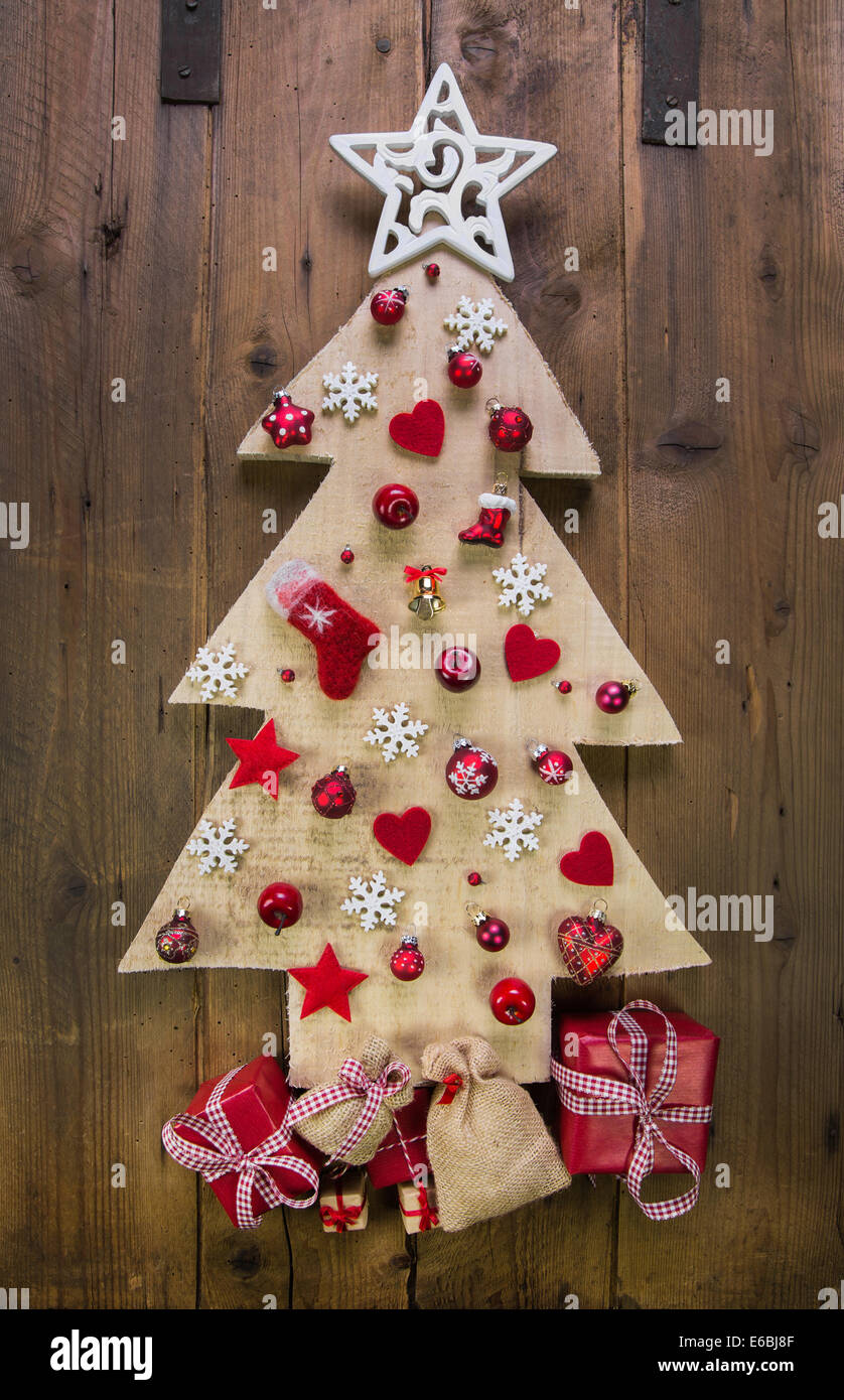 Decoration: handmade carved christmas tree with red and white miniatures. Stock Photo