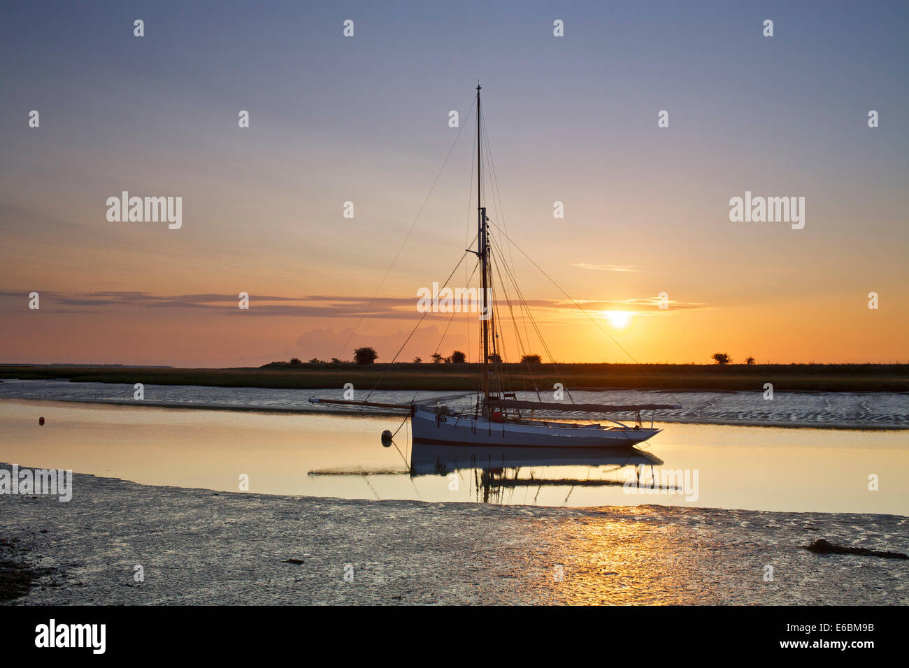 Faversham Creek, Kent, UK 20th August 2014. Sunrise at Faversham Creek lights up one of the last remaining seaworthy Whitstable Oyster Smacks, F76 Gamecock, the Yawl is over 100 years old having been launched in 1907. Cooler days and nights are forecast as the weather starts to turn slowly toward autumn. Stock Photo