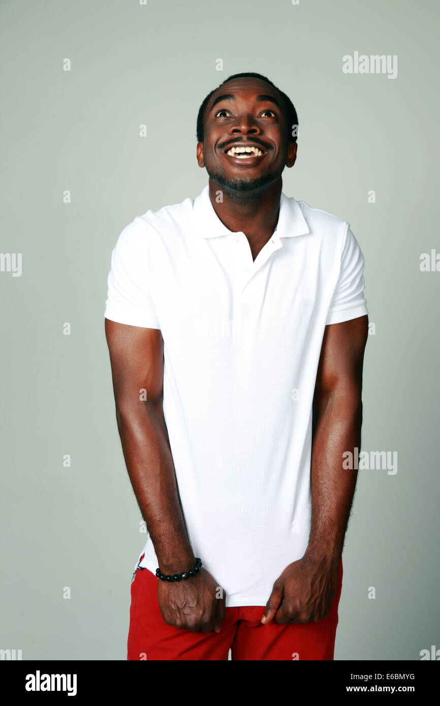 Funny african man looking up over gray background Stock Photo Alamy