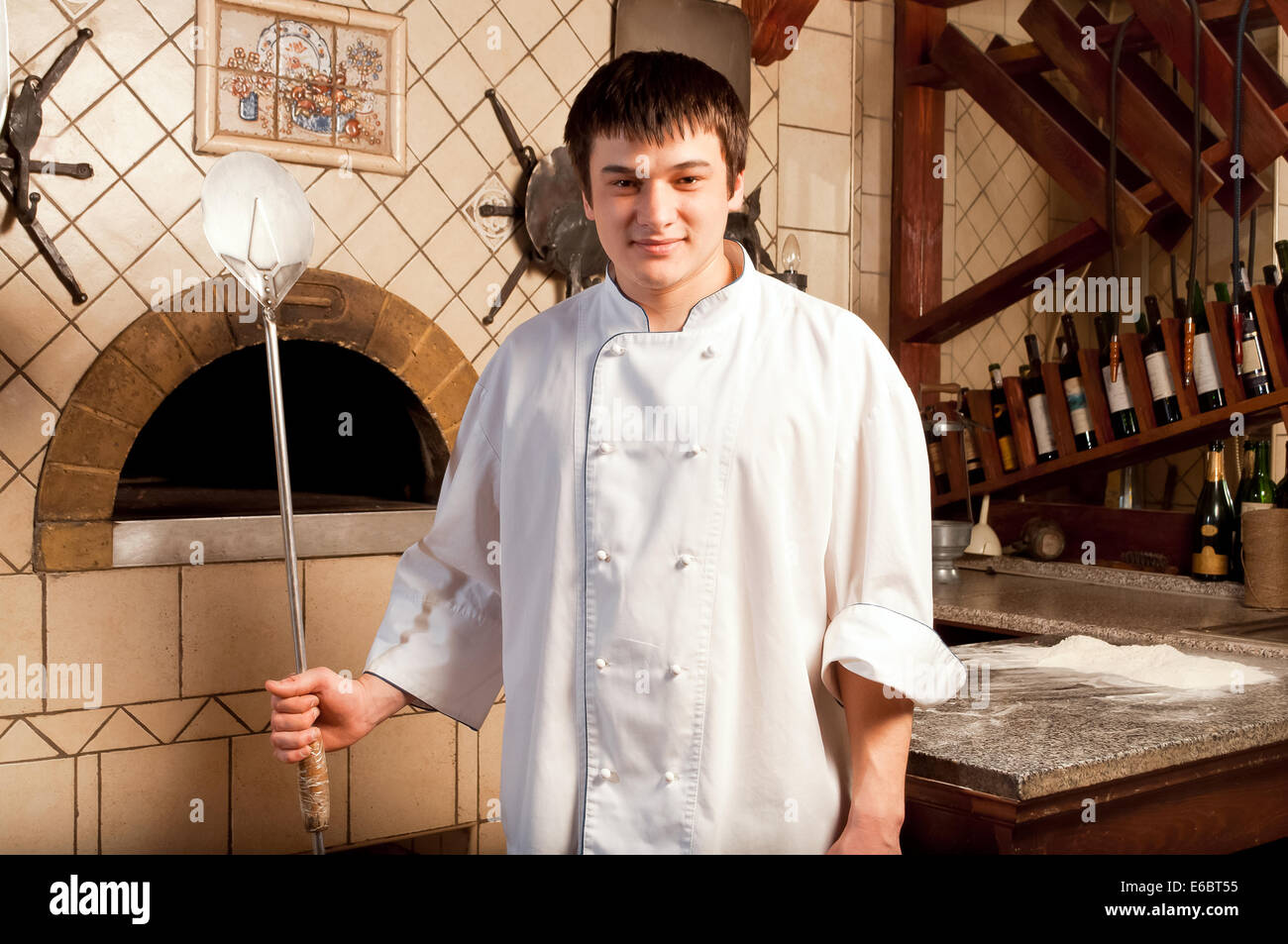 Young chef standing next to oven - indoor Stock Photo