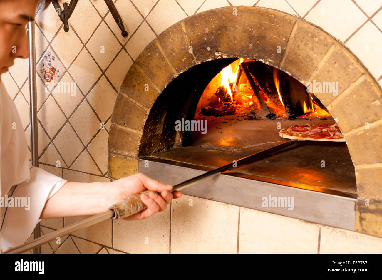 Baked pizza by the fire in traditional oven Stock Photo