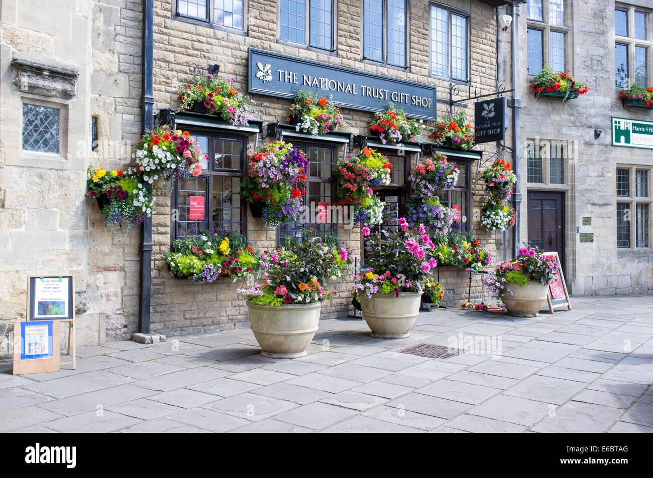 Hanging baskets of flowers outside National Trust gift shop in Wells
