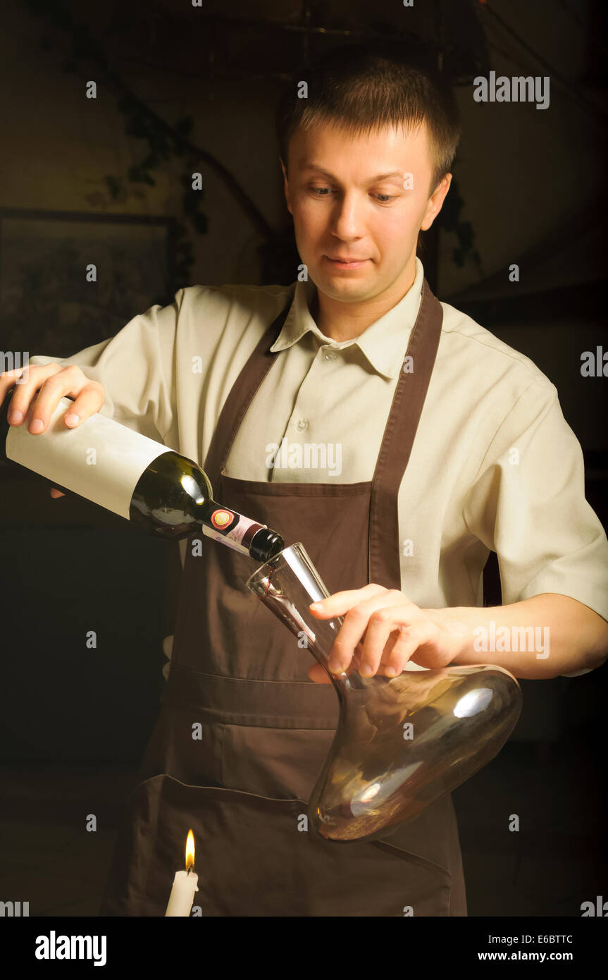 Sommelier pouring red wine into decanter Stock Photo