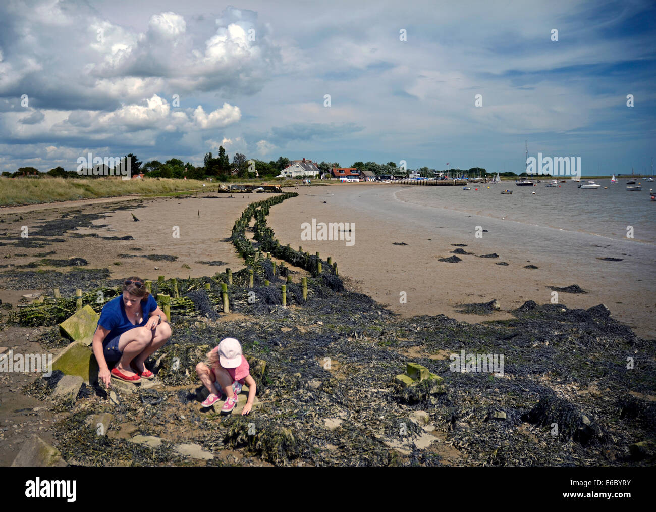 mother and child playing on river bed at orford suffolk england Stock Photo