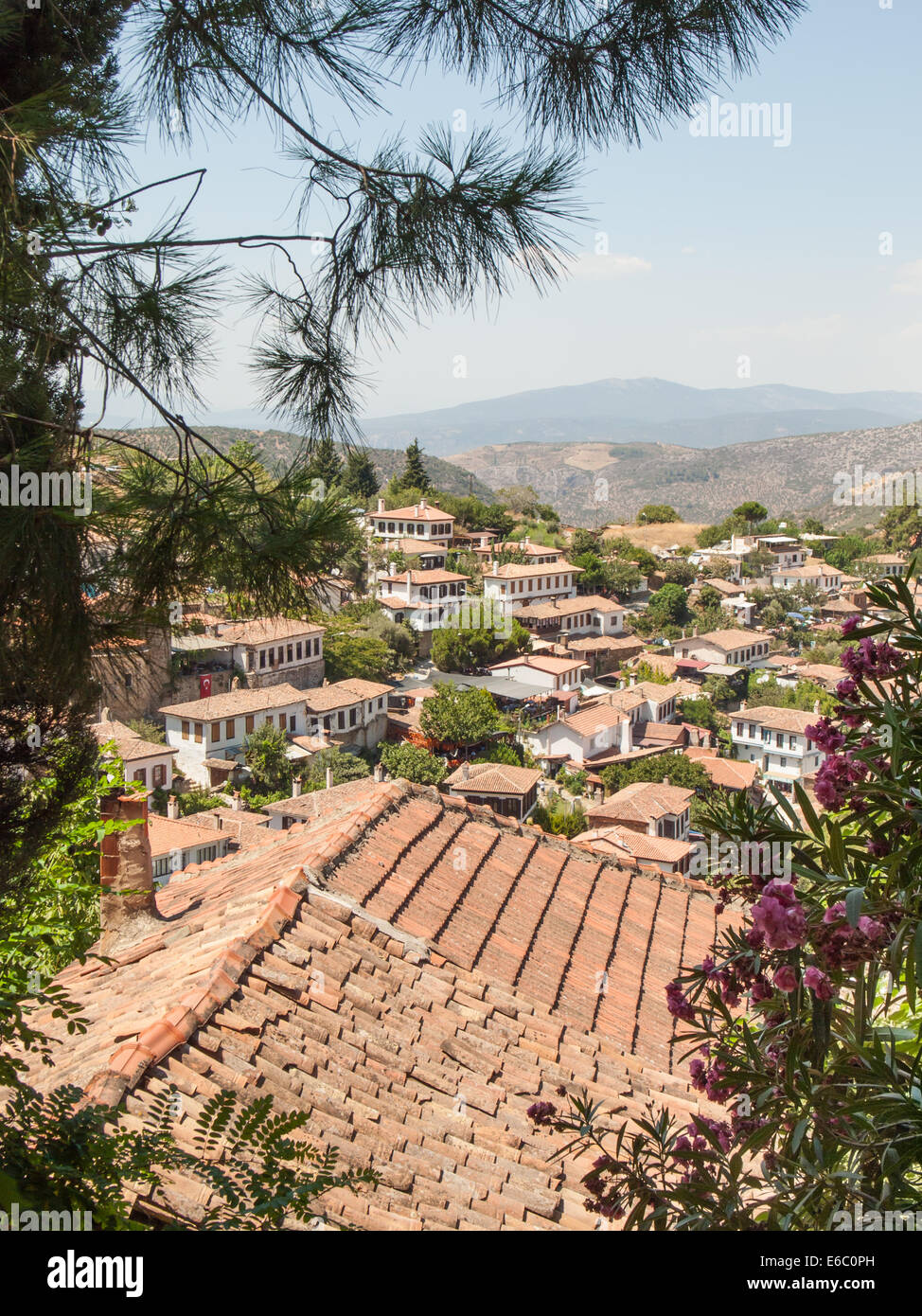 view over red tiled rooftop of the turkish village of sirince in izmir province through trees  on a sunny day Stock Photo