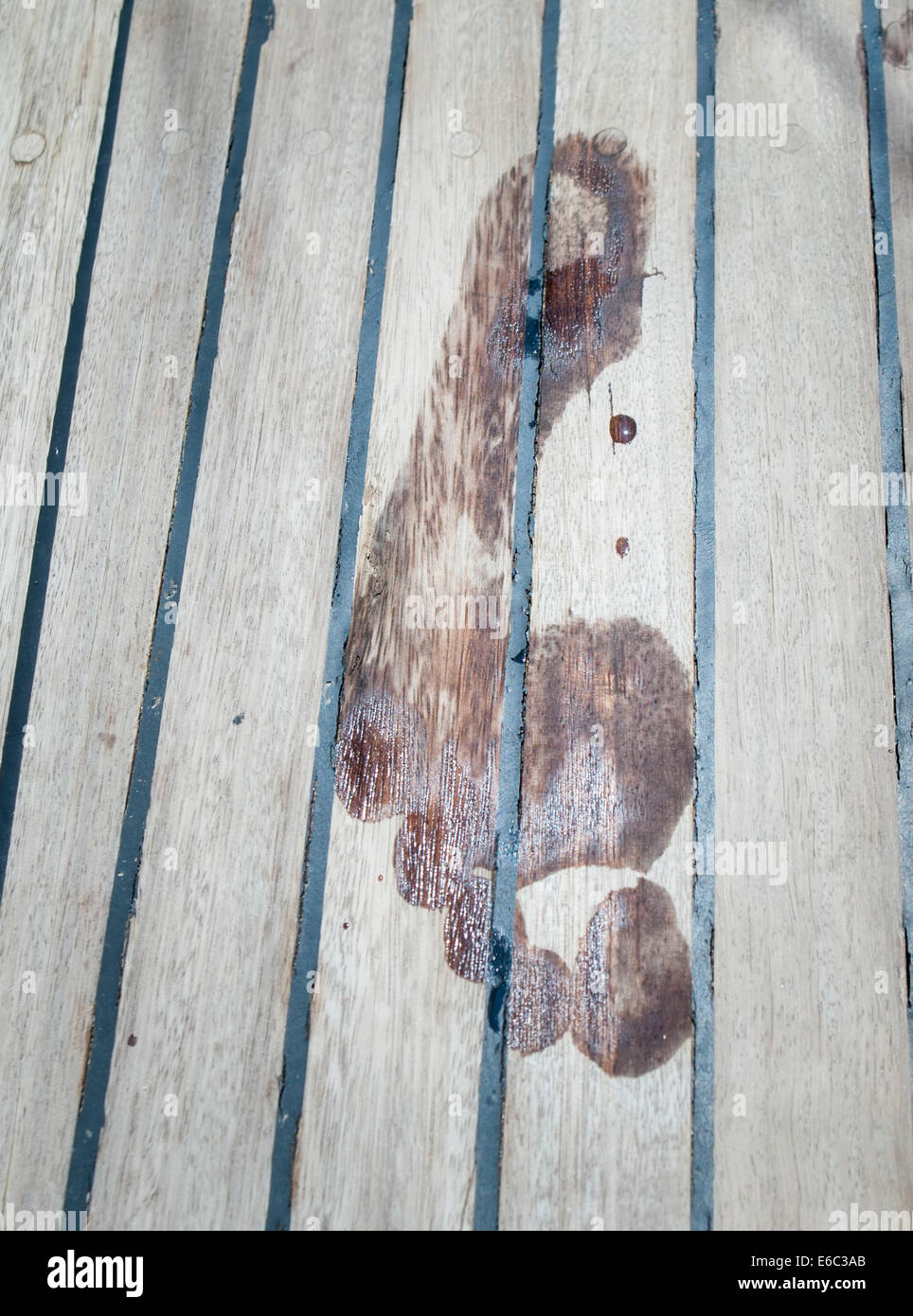 footprint made by a wet bare foot on a teak ships deck Stock Photo