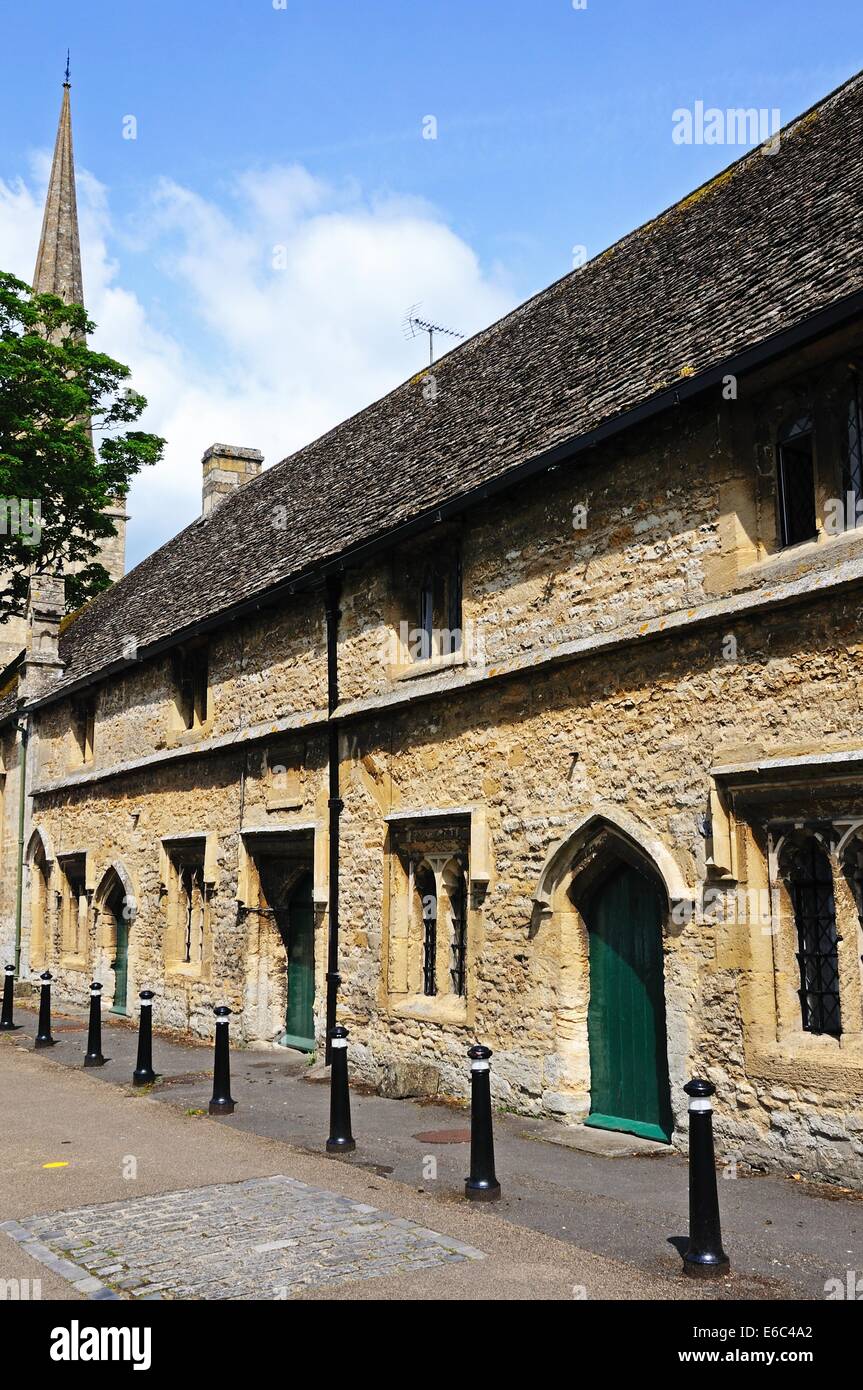 Almshouses with St John the Baptist church to the rear, Burford, Oxfordshire, England, UK, Western Europe. Stock Photo